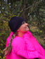 Laura looking up in forest while wearing hot pink hoverquilt